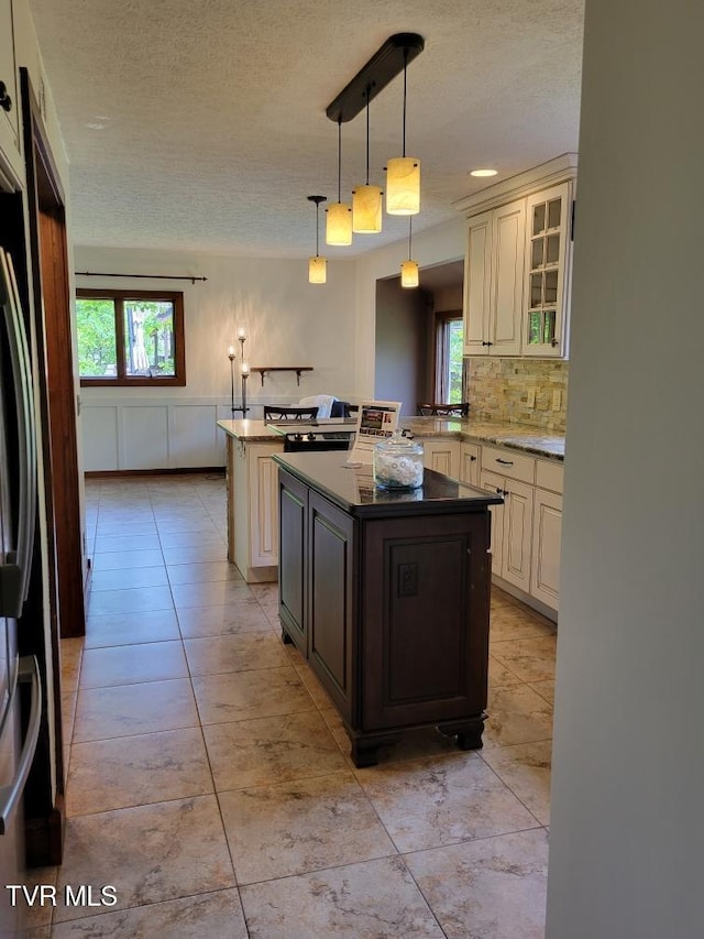 137 Columbine Rd, Kingsport, TN 37660 - kitchen featuring cream cabinetry, a textured ceiling, a kitchen island, and plenty of natural light