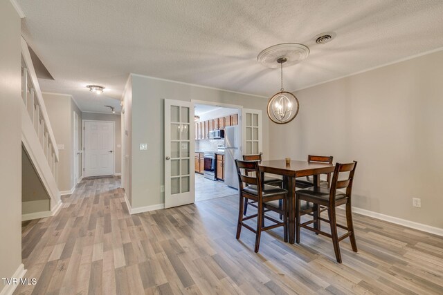 1127 Timbers E ., Unit Greeneville, TN 37745 - dining space featuring light wood-type flooring, a textured ceiling, a chandelier, ornamental molding, and baseboards