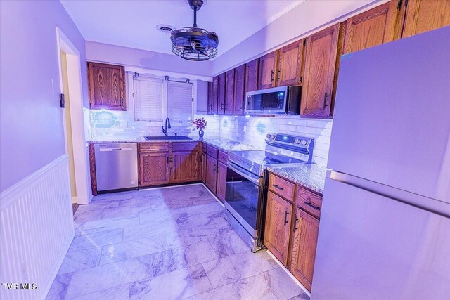 1127 Timbers E ., Unit Greeneville, TN 37745 - kitchen with stainless steel appliances, a sink, light stone countertops, decorative backsplash, and a wainscoted wall