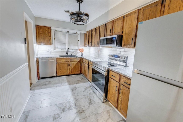 1127 Timbers E ., Unit Greeneville, TN 37745 - kitchen with stainless steel appliances, a sink, brown cabinets, backsplash, and light stone countertops