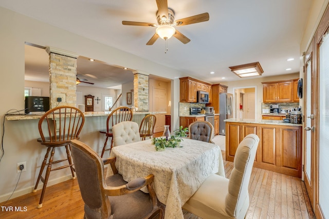 dining space featuring decorative columns, ceiling fan, light wood-type flooring, recessed lighting, and baseboards