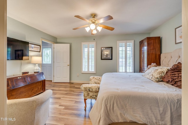 bedroom with light wood-type flooring, baseboards, and ceiling fan