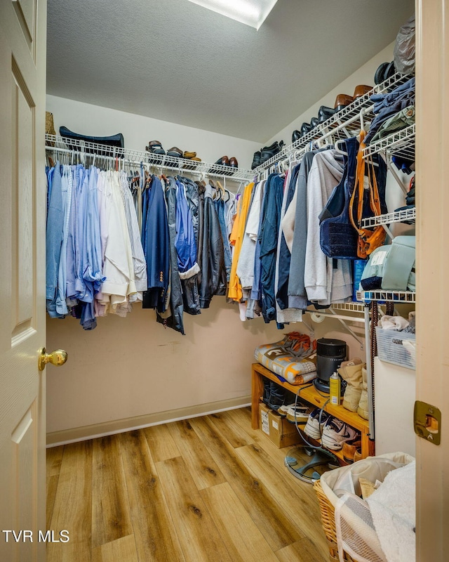 walk in closet with wood finished floors