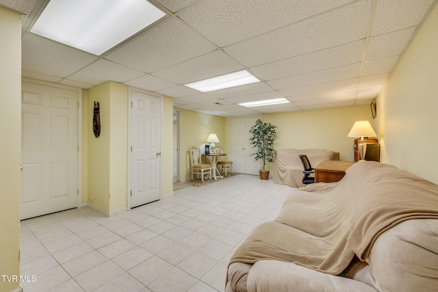 living area with light tile patterned flooring and a drop ceiling