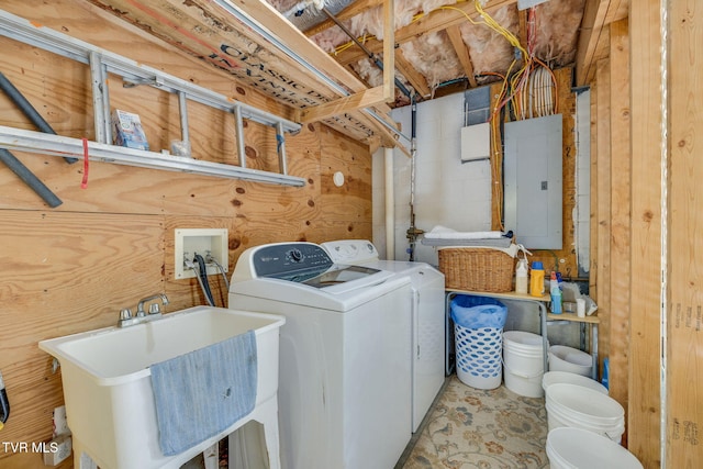 clothes washing area with electric panel, washing machine and clothes dryer, and a sink