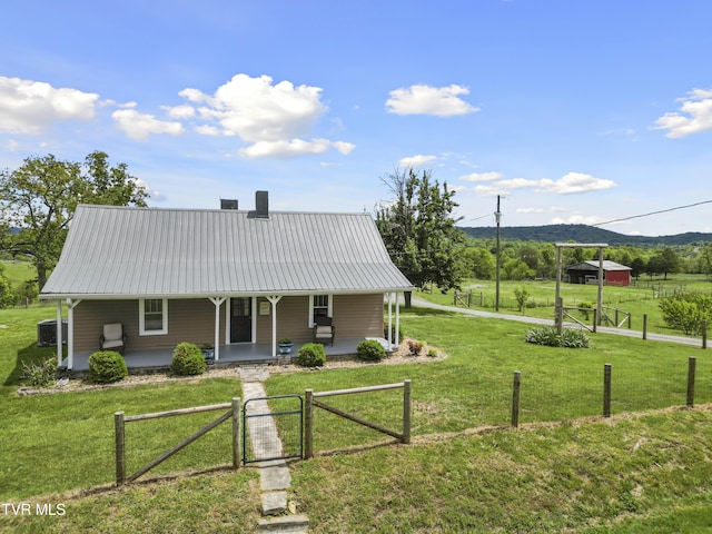 back of property featuring covered porch, a gate, a yard, metal roof, and a fenced front yard