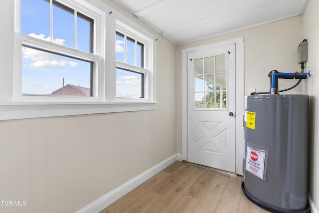 entryway featuring baseboards, light wood-style flooring, and electric water heater