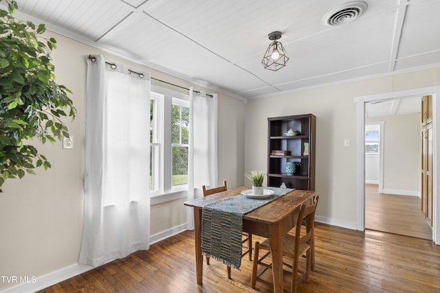 dining space featuring a healthy amount of sunlight, hardwood / wood-style flooring, baseboards, and visible vents
