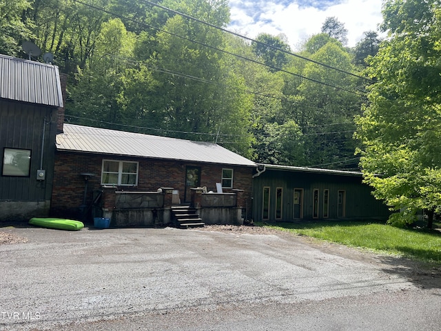 6430 Hoot Owl Hollow Rd, Norton, VA 24273 - view of front facade featuring board and batten siding, a forest view, and metal roof