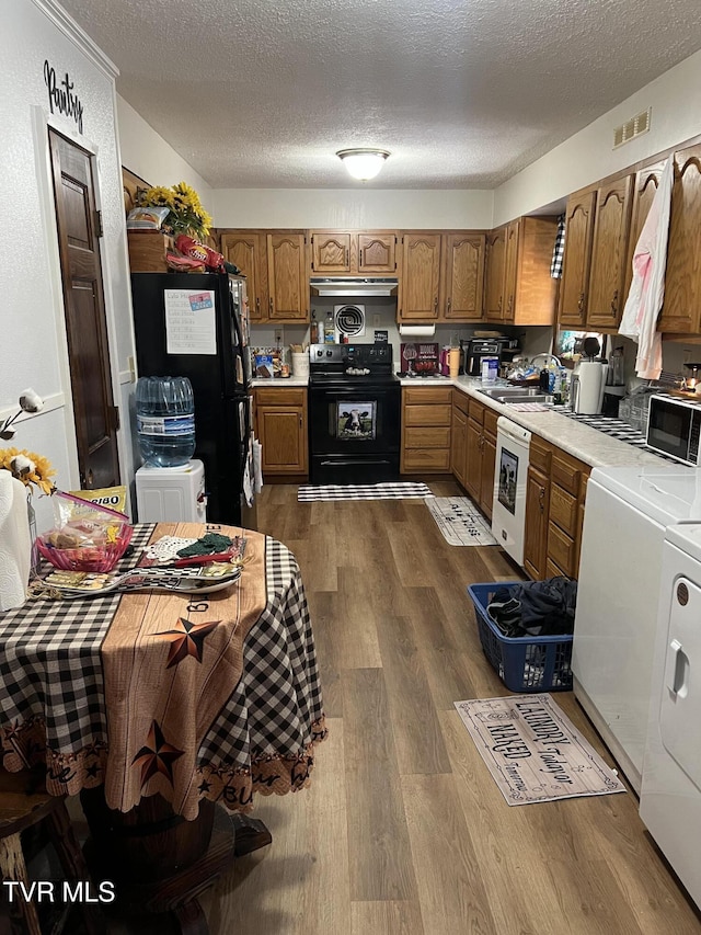 6430 Hoot Owl Hollow Rd, Norton, VA 24273 - kitchen featuring independent washer and dryer, visible vents, a sink, black appliances, and light countertops