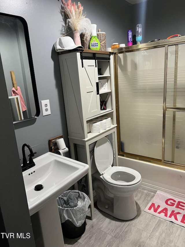 6430 Hoot Owl Hollow Rd, Norton, VA 24273 - bathroom with a sink, combined bath / shower with glass door, toilet, and wood finished floors