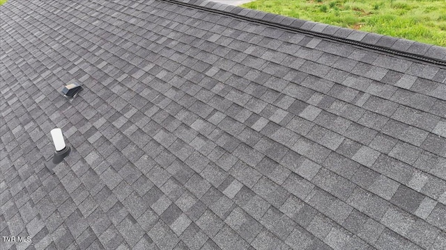 exterior details featuring roof with shingles