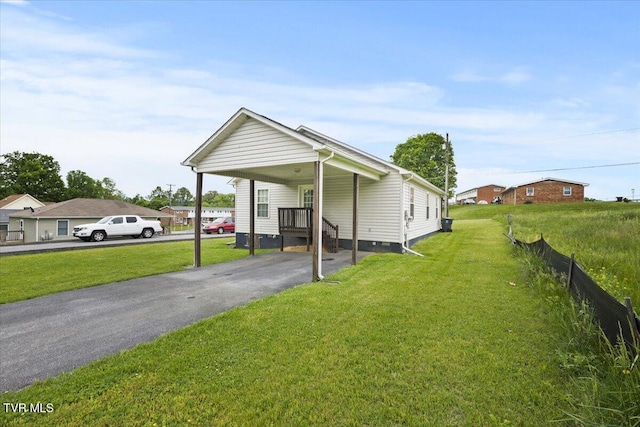 exterior space featuring driveway, a front yard, an attached carport, and crawl space