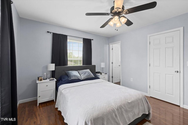 bedroom with baseboards, dark wood finished floors, and a ceiling fan