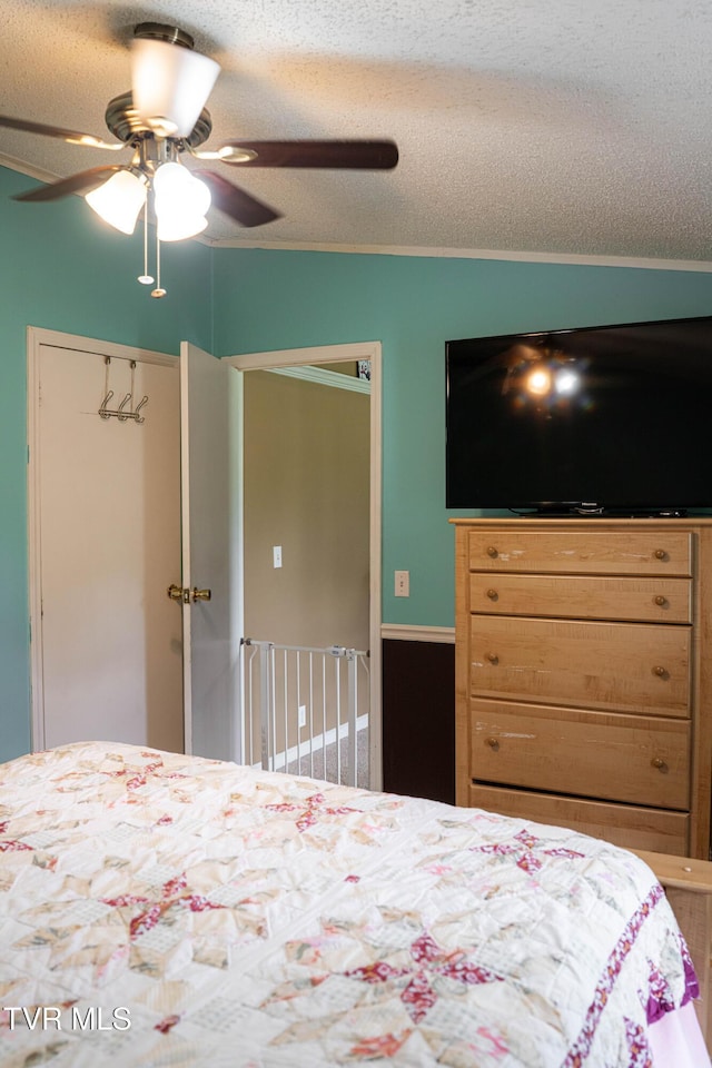 bedroom featuring a closet, a textured ceiling, and ceiling fan