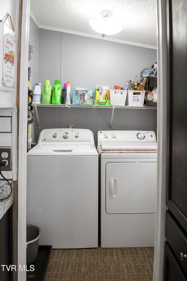 laundry room with washing machine and dryer, laundry area, a textured ceiling, and ornamental molding