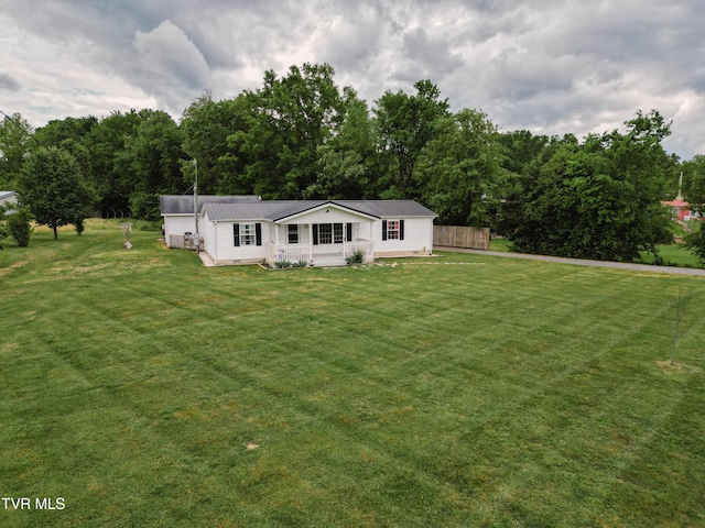 view of front facade featuring metal roof and a front lawn