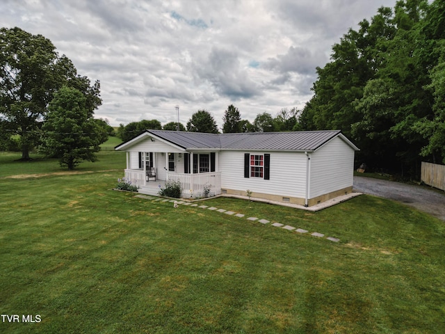 view of front of house featuring a front lawn, a porch, driveway, and metal roof
