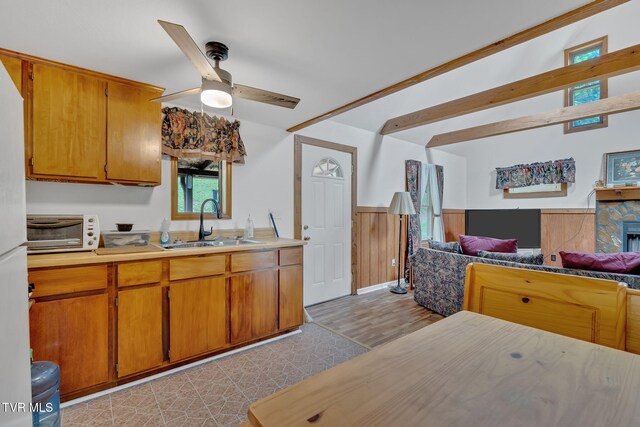 4331 Sentry Rd, Big Stone Gap, VA 24219 - kitchen featuring a sink, open floor plan, a wainscoted wall, ceiling fan, and brown cabinets