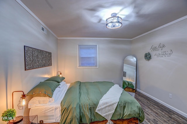 bedroom featuring baseboards, crown molding, and wood finished floors