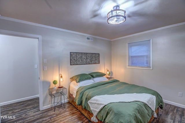 bedroom featuring crown molding, baseboards, visible vents, and wood finished floors