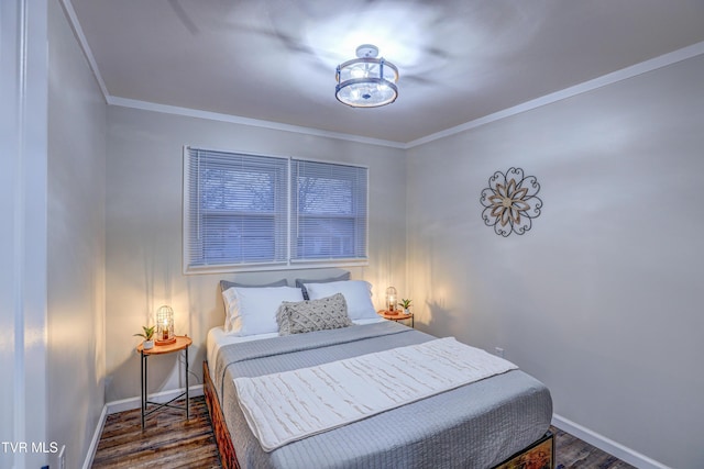 bedroom with crown molding, baseboards, and wood finished floors