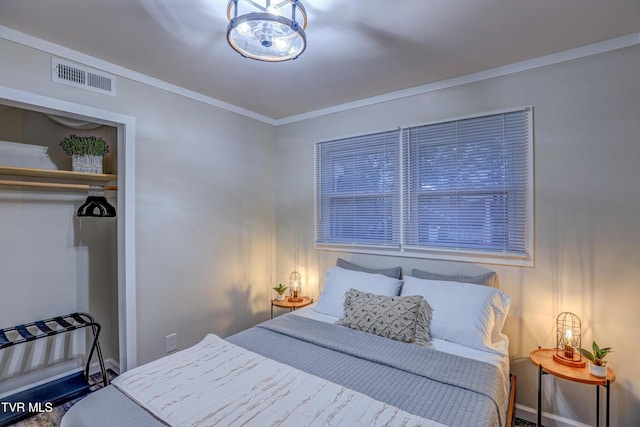 bedroom featuring ornamental molding, a closet, and visible vents