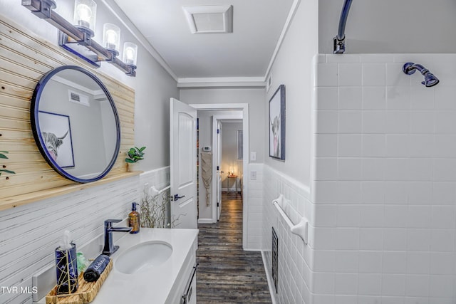 bathroom with ornamental molding, visible vents, a wainscoted wall, and wood finished floors