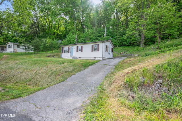 23249 Marys Chapel Rd, Bristol, VA 24202 - manufactured / mobile home with asphalt driveway, a front yard, a wooded view, and crawl space