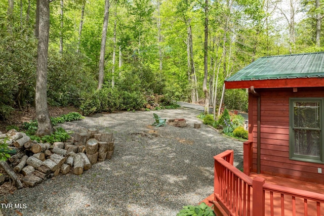 view of yard featuring a wooded view and a patio