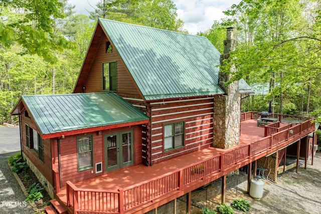 rear view of property with metal roof, french doors, and a wooden deck