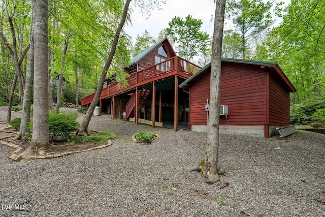 rear view of property with stairway and a deck