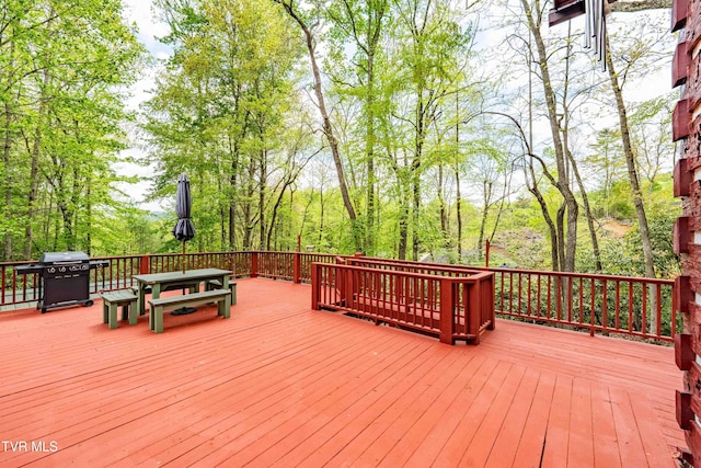 wooden terrace with outdoor dining area and a grill