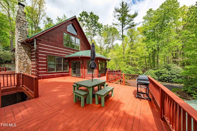 wooden deck with outdoor dining area and a grill