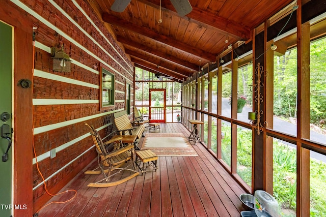 sunroom featuring a ceiling fan and beamed ceiling