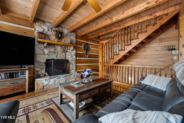 living area featuring wooden ceiling, a fireplace, wood-type flooring, and beamed ceiling