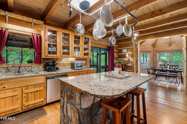 kitchen with a sink, beam ceiling, stainless steel dishwasher, wood ceiling, and light wood-style floors