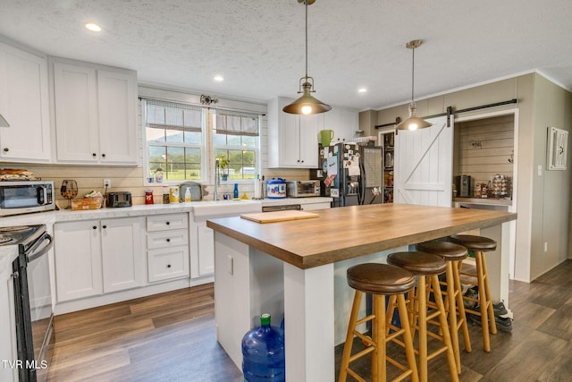 100 Colyer Rd, Greeneville, TN 37743 - kitchen featuring butcher block counters, a sink, black appliances, a barn door, and dark wood finished floors