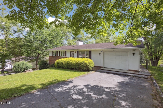 single story home with a garage, a front lawn, asphalt driveway, and a chimney