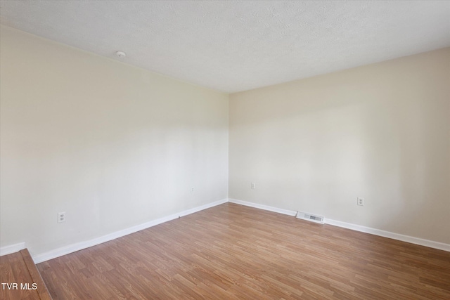 unfurnished room with wood finished floors and baseboards
