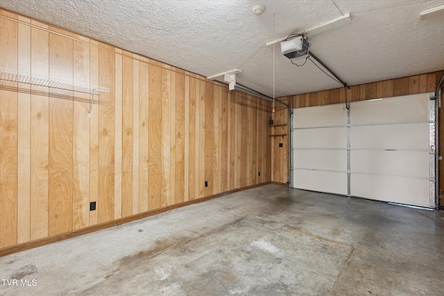 garage featuring a garage door opener and wooden walls