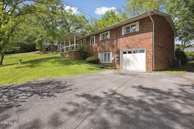 view of home's exterior with driveway, a garage, brick siding, and central air condition unit