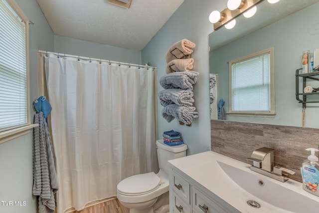 bathroom featuring a textured ceiling, toilet, curtained shower, vanity, and wood finished floors