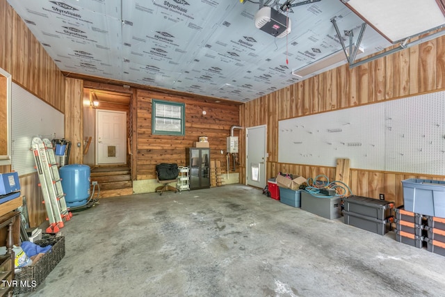garage with wood walls and a garage door opener