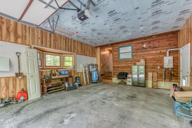 garage featuring wood walls, water heater, and a garage door opener