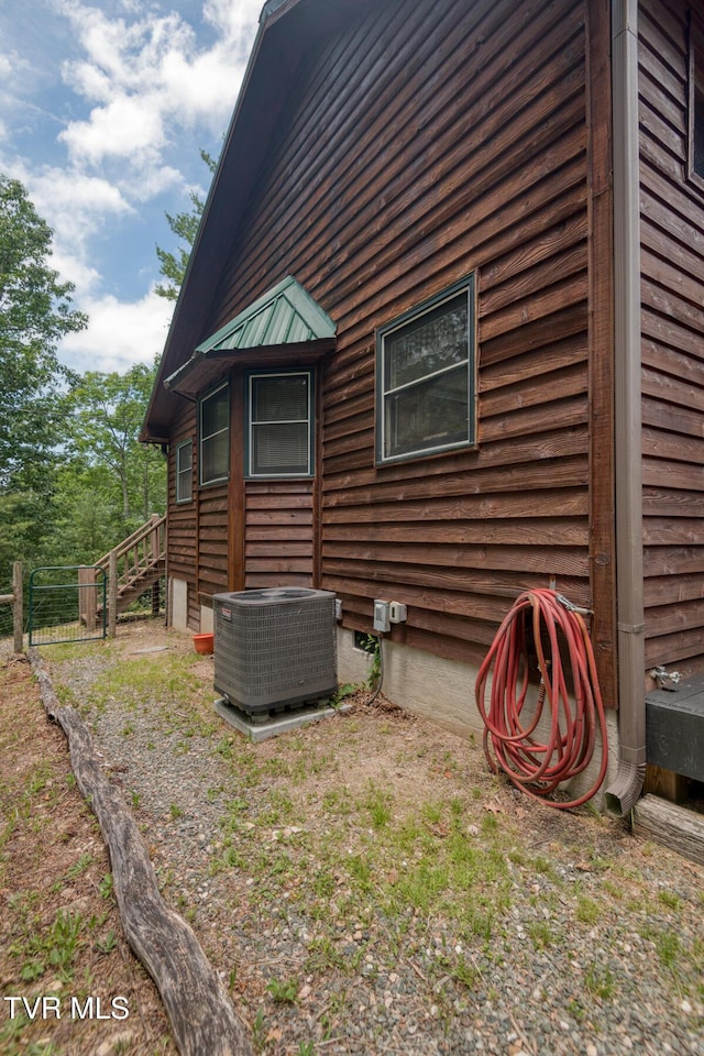 view of side of property featuring central air condition unit and fence