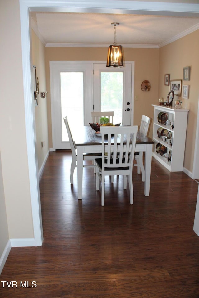 dining space featuring ornamental molding, dark wood-type flooring, and baseboards