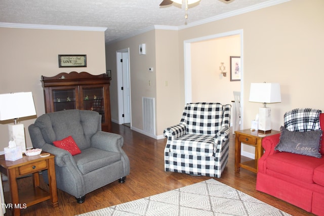 living area with a ceiling fan, wood finished floors, baseboards, crown molding, and a textured ceiling