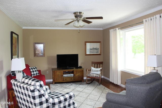 living room featuring light wood-style flooring, a ceiling fan, ornamental molding, and baseboards