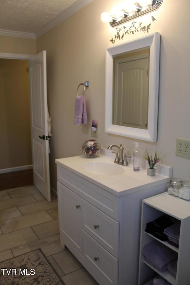 bathroom with vanity, ornamental molding, and a textured ceiling